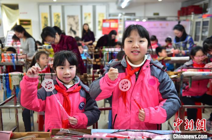 圖為小學(xué)生展示繡制好的2022年北京冬奧會吉祥物“冰墩墩”形象?！∮髟屏?攝