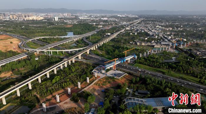 航拍正在建設(shè)的跨越成都繞城高速公路連續(xù)梁施工現(xiàn)場，旁邊依次為已運營的成渝高速鐵路和機場高速公路?！⒅铱?攝