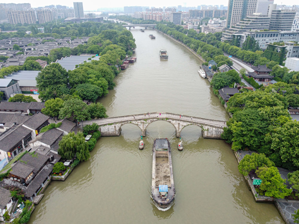 5月27日，一艘貨船駛過京杭大運(yùn)河南端標(biāo)志建筑杭州拱宸橋。(無人機(jī)照片)新華社記者江漢 攝