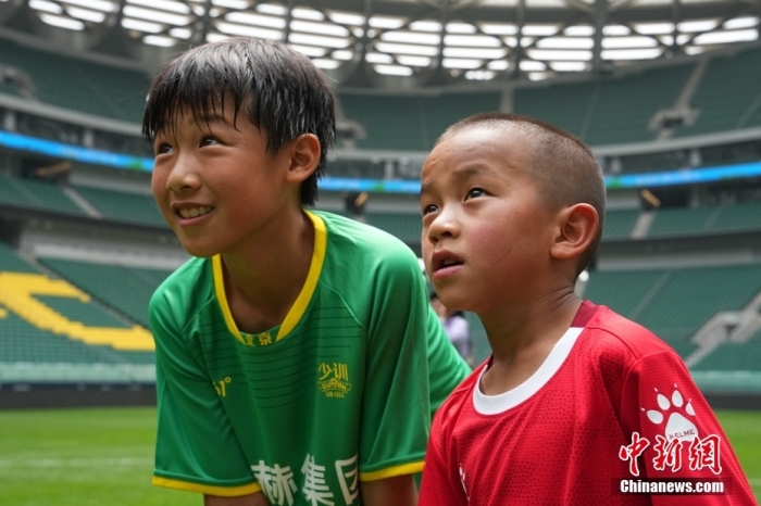 圖為北京國(guó)安小球員陳小北和7歲的俄金仁增在一起觀看場(chǎng)內(nèi)播放的紀(jì)錄片。<a target='_blank' href='/' _fcksavedurl='/'><p  align=