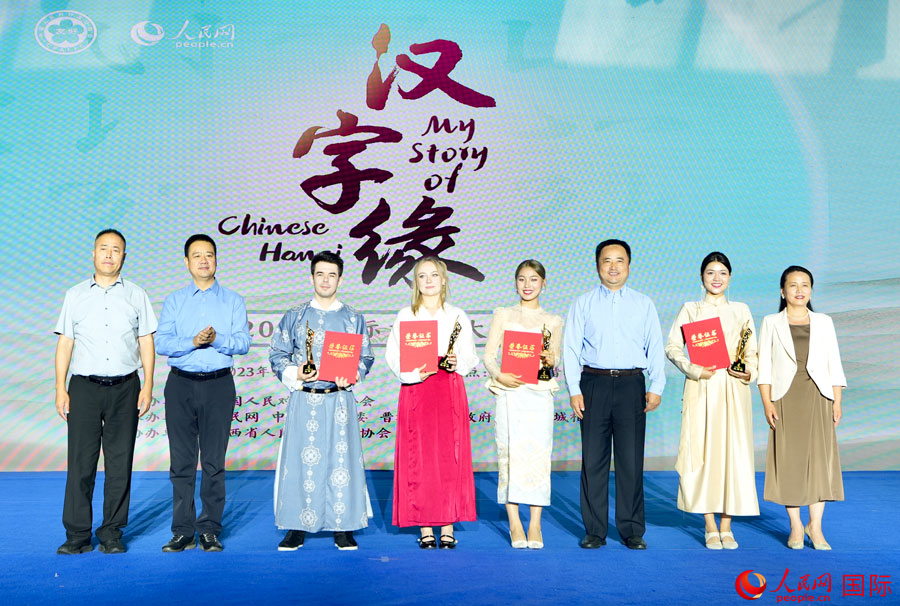 人民日報社對外交流合作部處長張寧斌（右三），晉城市委宣傳部副部長、市政府新聞辦主任李建亮（左二），晉城市委宣傳部副部長、網(wǎng)信辦主任賈苗麗（右一），陽城縣委常委、宣傳部部長常軒勝（左一）為三等獎選手頒獎。人民網(wǎng) 盧鵬宇攝