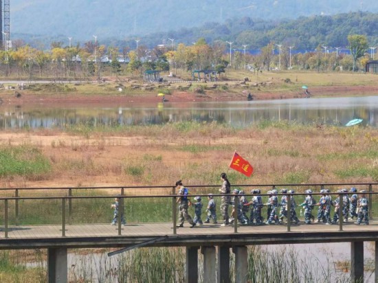 　　10月24日，秋游的幼兒園小朋友在老師帶領(lǐng)下走在清水塘公園里的木橋上。本報(bào)記者 常雯宜攝