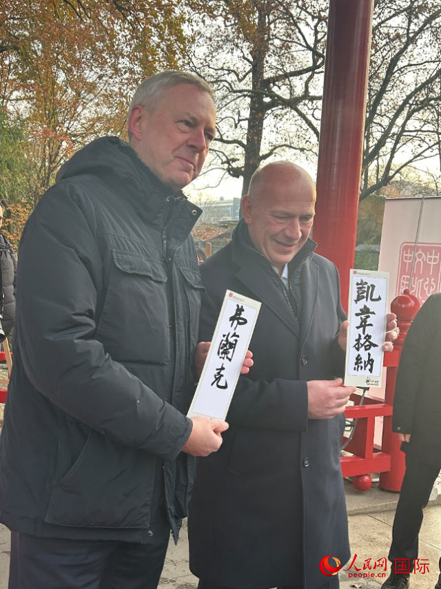 柏林市長(zhǎng)韋格納（右）、動(dòng)物園監(jiān)事會(huì)主席布魯克曼（左）手持中國(guó)文化中心工作人員現(xiàn)場(chǎng)手書的中文名字。人民網(wǎng)記者 徐馨攝