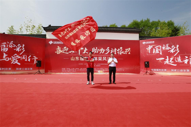 為媒體采風(fēng)團(tuán)授旗。 山東省福彩供圖
