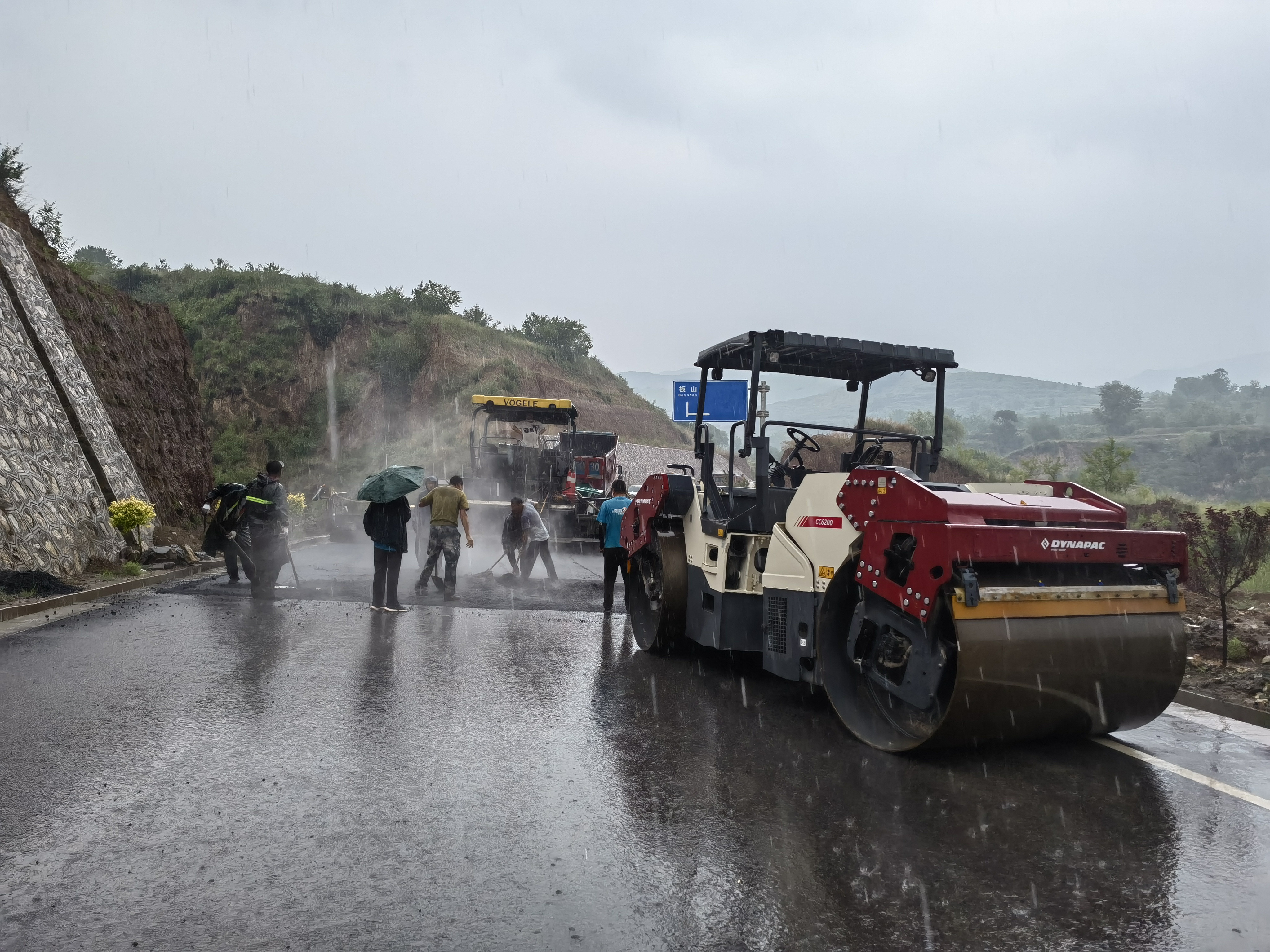 路橋工人在大雨中搶修道路。李華英 攝