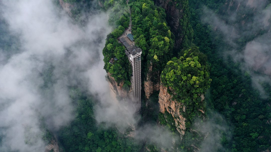 位于張家界武陵源景區(qū)的百龍?zhí)焯蓁偳对谠旗F繚繞的峰林間，雄偉壯觀。吳勇兵攝