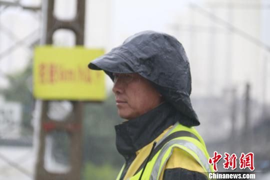 蘭州西工務(wù)段蘭州線路車(chē)間防護(hù)員雨中巡查?！⊥豕廨x 攝