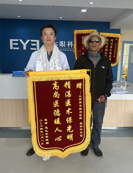 達瓦老人向吳四華（左）贈送錦旗。受訪者供圖