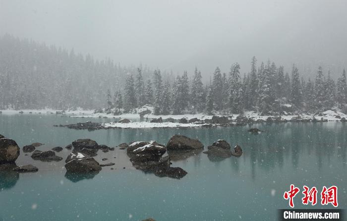 然烏湖春雪飄落美如畫(huà)游客湖邊拍照賞景