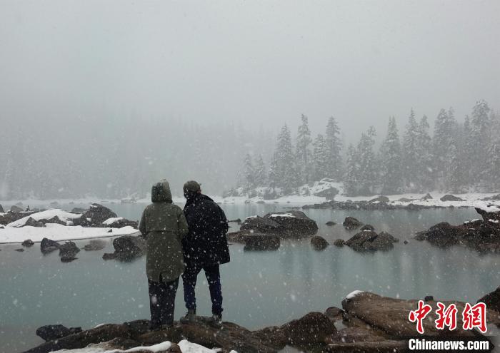 游客欣賞雪中然烏湖。　冉文娟 攝