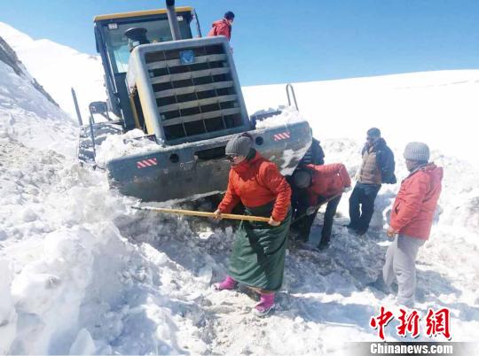 圖為普布卓瑪(左一)與養(yǎng)護工人一起抗擊雪災(zāi)，搶險保通?！“⒗锏貐^(qū)公路養(yǎng)護段供圖 攝