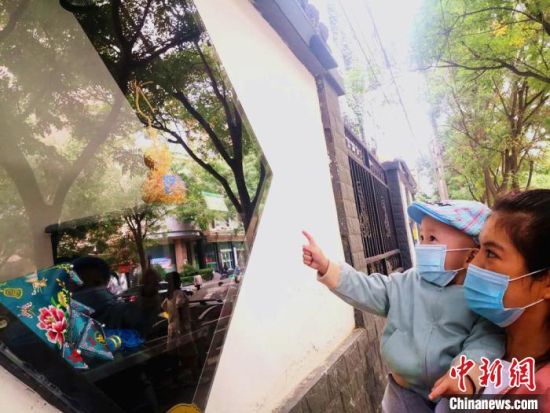 圖為蘭州市民在街頭觀賞刺繡和刻葫蘆的非遺展示。(資料圖) 史靜靜 攝