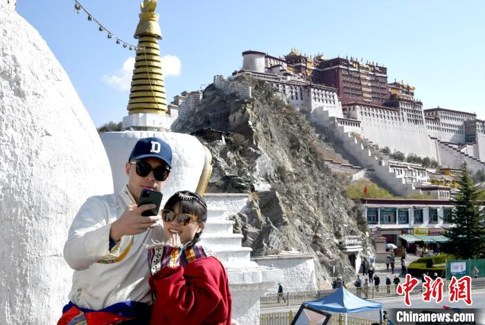 4月17日，游客身著藏式元素服裝在拉薩布達拉宮觀景臺拍照留念?！±盍?攝