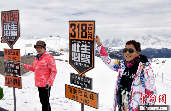 圖為5月14日，西藏林芝色季拉山觀景臺，游客與南迦巴瓦峰合影?！±盍?攝
