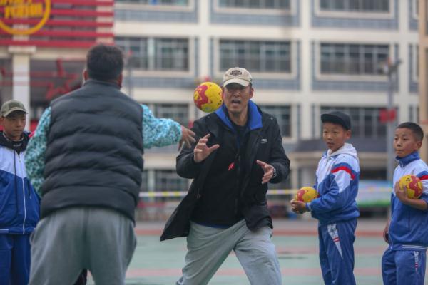 在高原上教孩子們打手球，“慢慢兒來，甭著急！”