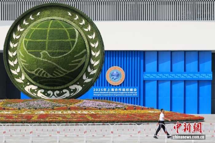 8月31日，天津，一名工作人員從2025年上海合作組織峰會主會場外的景觀花壇旁經(jīng)過。當(dāng)日，2025年上海合作組織峰會在天津舉行。<a target='_blank' href='/'><p  align=