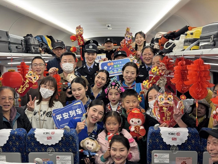 春節(jié)期間，在中老鐵路磨萬（磨丁—萬象）段，鐵路客運員工與乘客合影留念。李加勇攝