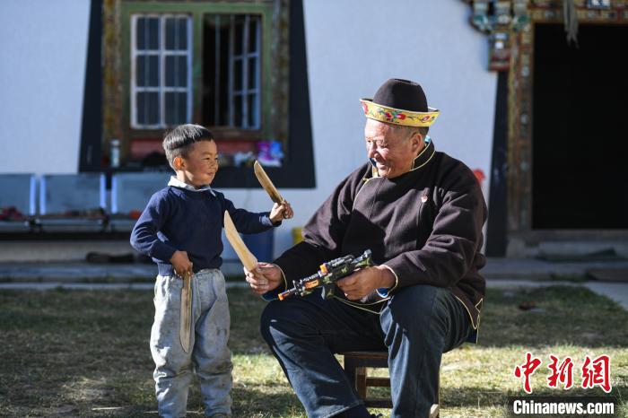 圖為米林縣扎西繞登鄉(xiāng)彩門村64歲的洛桑帶著孫子巴桑在院子的草地上玩耍?！『闻罾?攝