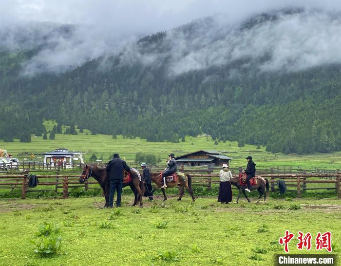 6月10日，游客在魯朗小鎮(zhèn)高山牧場景區(qū)體驗騎馬?！∪轿木?攝