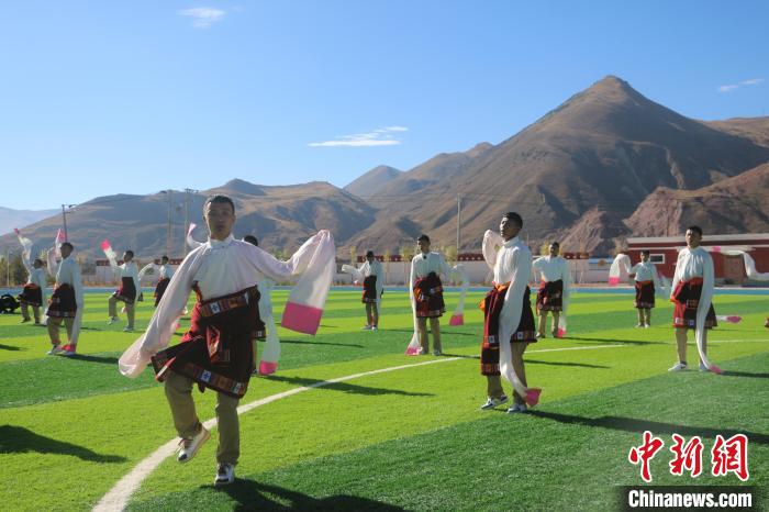 圖為青海師范大學(xué)附屬玉樹實驗學(xué)校學(xué)生在綠茵場跳起囊謙古舞—卓根瑪?！〕逃?攝