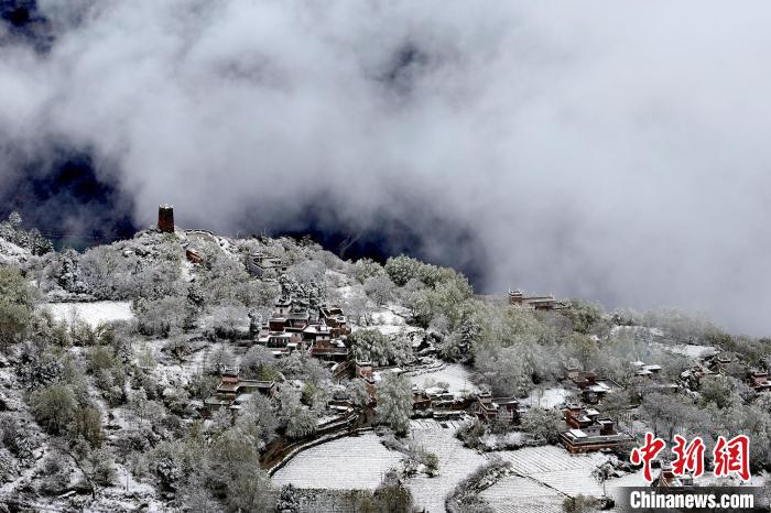 雪后的藏寨和碉樓構(gòu)成美麗的雪景?！〗党鯘衫?攝