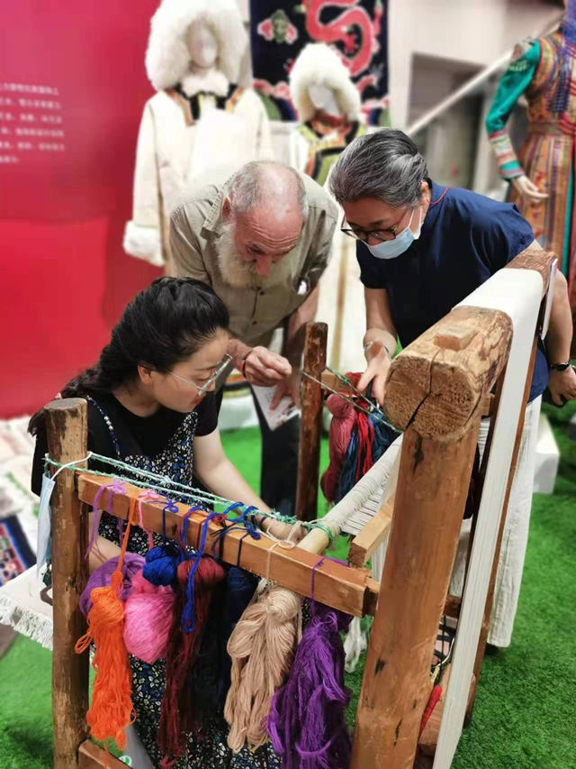 楊永良的學(xué)生在展會(huì)上向客商介紹加牙藏毯編織技藝。受訪者供圖