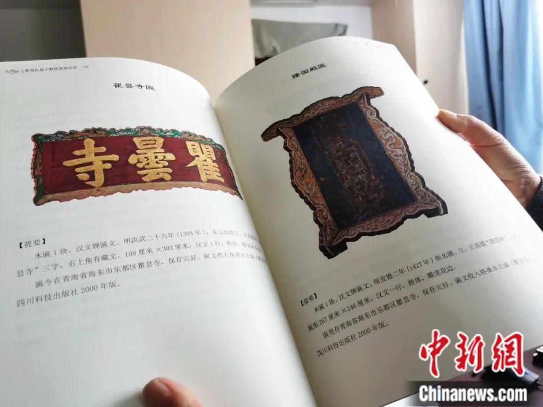古籍保護人員展示介紹明代朱元璋撰寫的青海瞿曇寺匾(左)的出版書籍。張?zhí)砀?攝