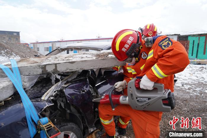 圖為地震實(shí)戰(zhàn)拉動現(xiàn)場，參演人員進(jìn)行車輛破拆?！∮駱湎拦﹫D