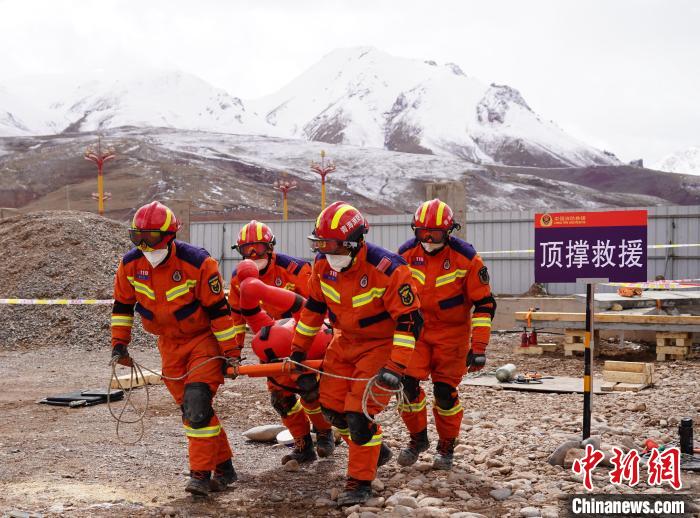 圖為地震實(shí)戰(zhàn)拉動現(xiàn)場，參演人員正在轉(zhuǎn)移受傷人員?！∮駱湎拦﹫D