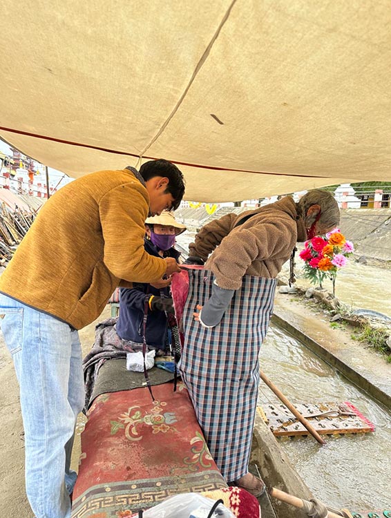扎西奪爾登為路邊老人送去保暖圍腰。阿壩州文明辦供圖