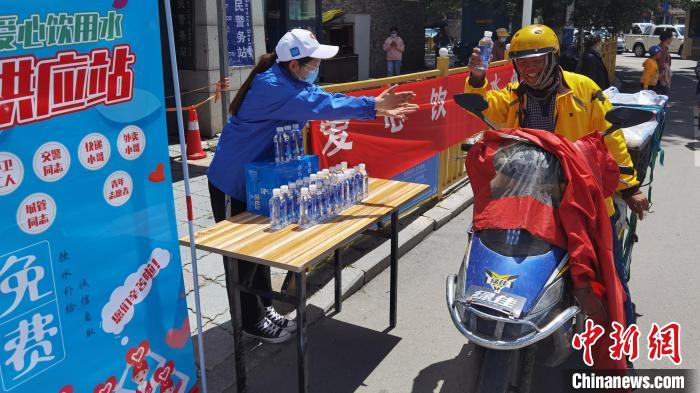 圖為近日，西藏自治區(qū)青年志愿者協(xié)會(huì)志愿者在拉薩街頭向快遞員送水。西藏自治區(qū)青年志愿者協(xié)會(huì) 供圖