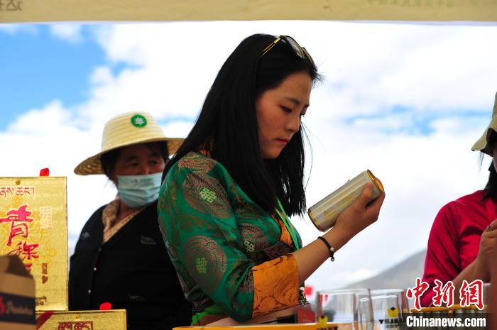 圖為拉薩市民在特色農(nóng)畜產(chǎn)品展示展銷會上選購商品?！垈?攝