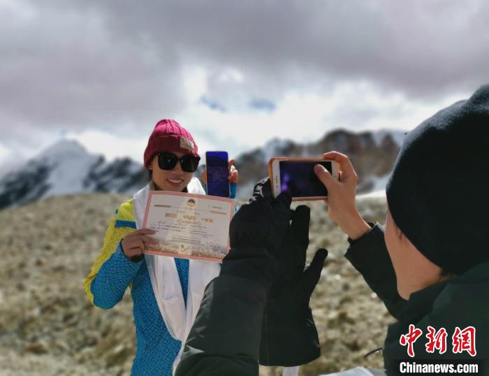 圖為5日，登頂洛堆峰的登山者獲得西藏自治區(qū)登山協(xié)會頒發(fā)的登頂證明?！垈?攝