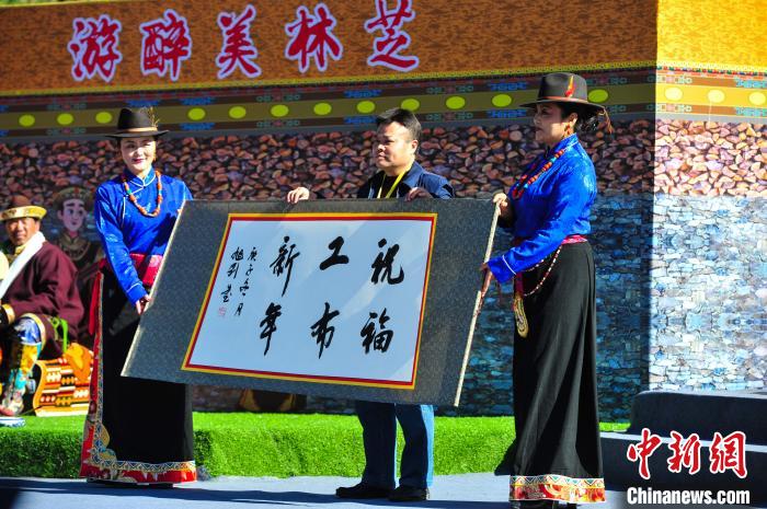 圖為14日，當(dāng)?shù)孛癖娛謱?xiě)工布新年賀詞。　張偉 攝