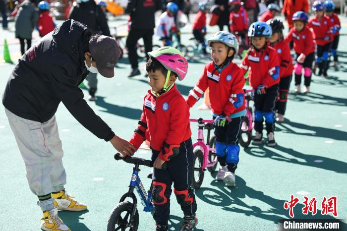 圖為拉薩市實驗幼兒園孩子們在教練的指導(dǎo)下練習滑步車?！『闻罾?攝