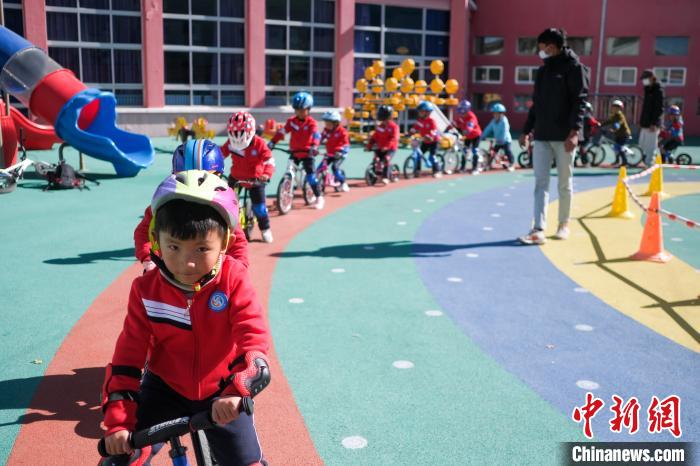 圖為拉薩市實驗幼兒園孩子們在教練的指導(dǎo)下練習滑步車?！『闻罾?攝