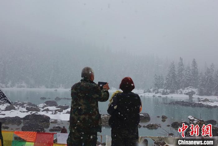 游客欣賞雪中然烏湖。　冉文娟 攝