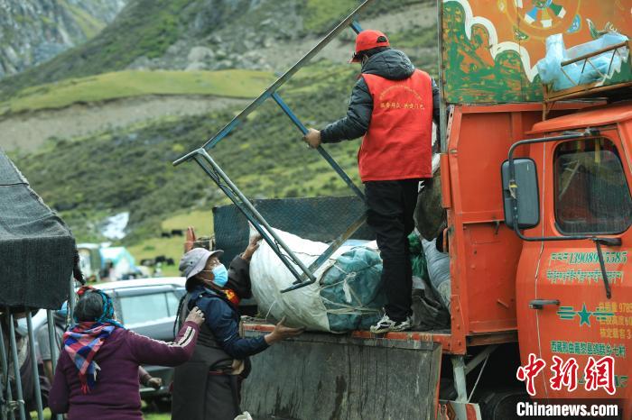 圖為工作人員幫助牧民們卸家具?！÷蹇?攝