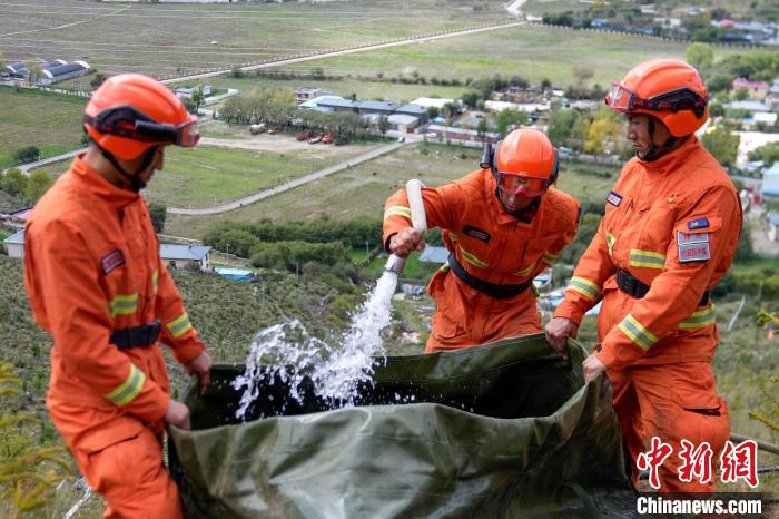 技能大練兵過(guò)程中，消防員在陡坡上向蓄水池注水?！±顕?guó)燾 攝