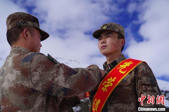 排長王朝偉(圖左)給退伍老兵佩戴大紅花。　西藏山南軍分區(qū)某團(tuán)供圖