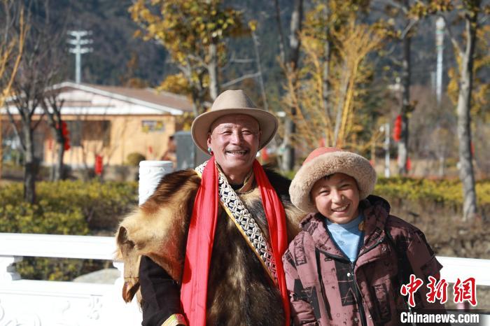 圖為林芝市巴宜區(qū)布久鄉(xiāng)仲果村村民桑杰與孫子一起參加藏歷新年活動(dòng)?！埩?攝