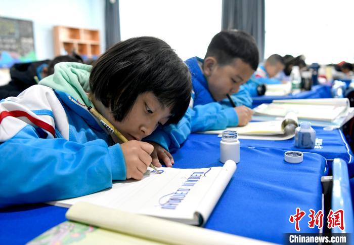 3月14日，西藏拉薩市第一小學(xué)一年級(jí)六班的學(xué)生們?cè)诓卣Z(yǔ)文課上書(shū)寫藏文。　李林 攝