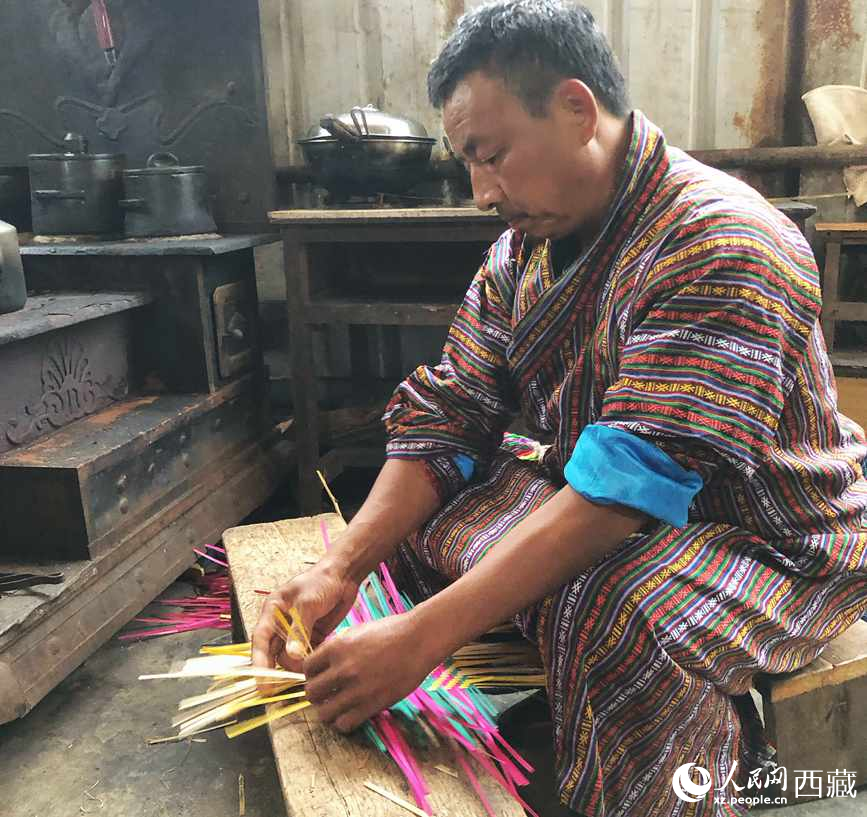 門巴族漢子愛明正在編織藤竹品。