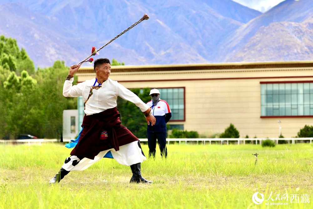 參賽選手在拉薩首屆農(nóng)牧民運(yùn)動(dòng)會(huì)上進(jìn)行“古朵”比賽（“古朵”指的是用牦牛毛或者山羊毛編織成的拋石繩，可以將石頭投擲到較遠(yuǎn)的地方，是牧民們用來放牧的工具）。