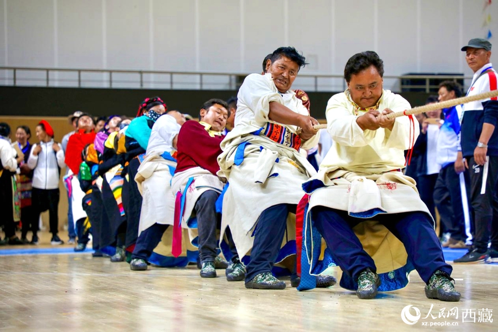 身著民族服裝的農(nóng)牧民選手在拔河比賽現(xiàn)場。